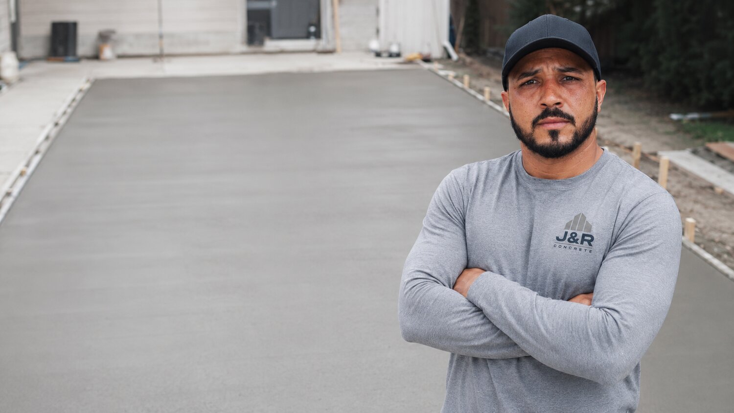 Fabio Jr., owner of J&R Contracting & Concrete, on a finished concrete driveway