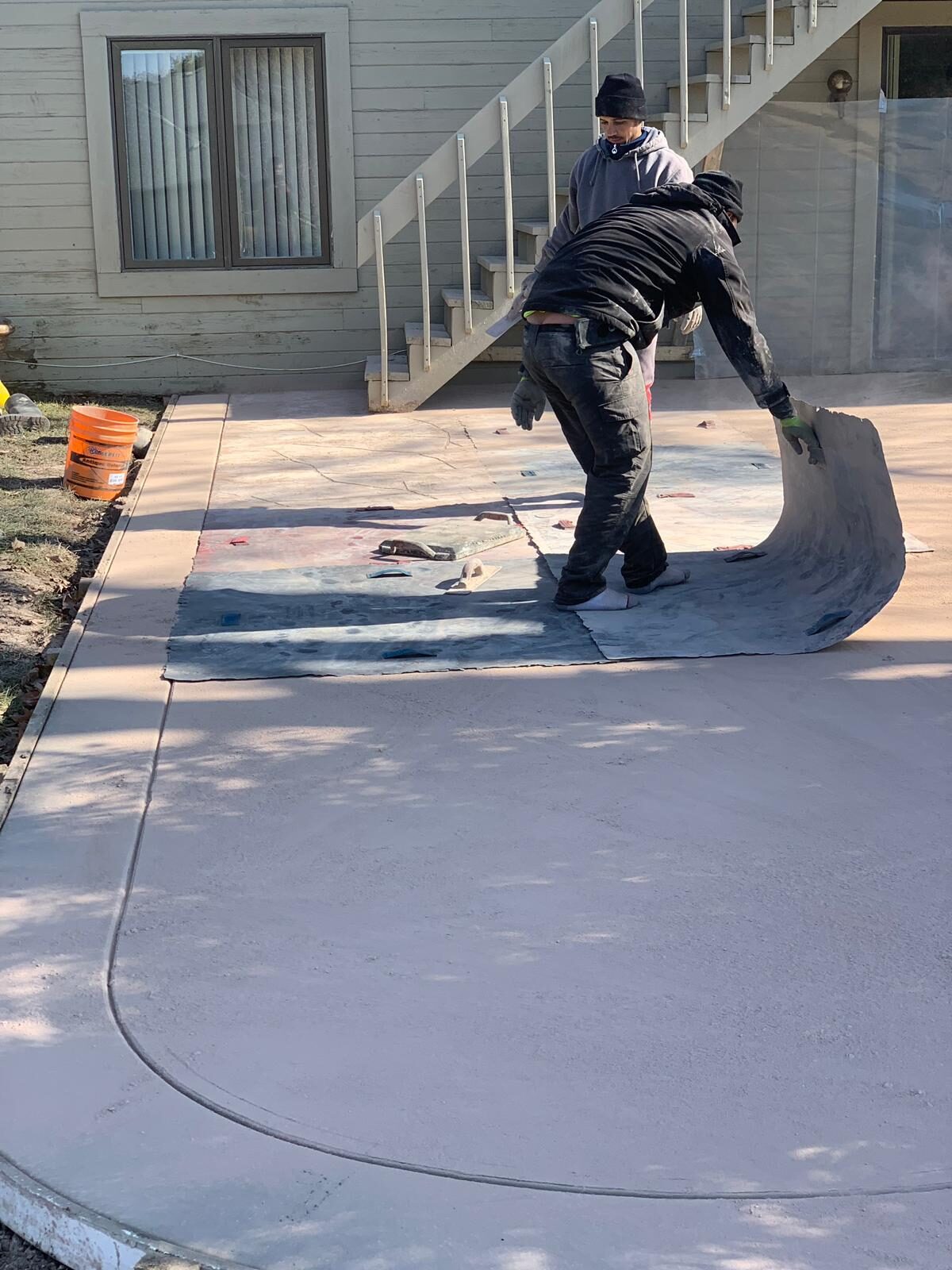 Crew hand-finishing a new concrete patio
